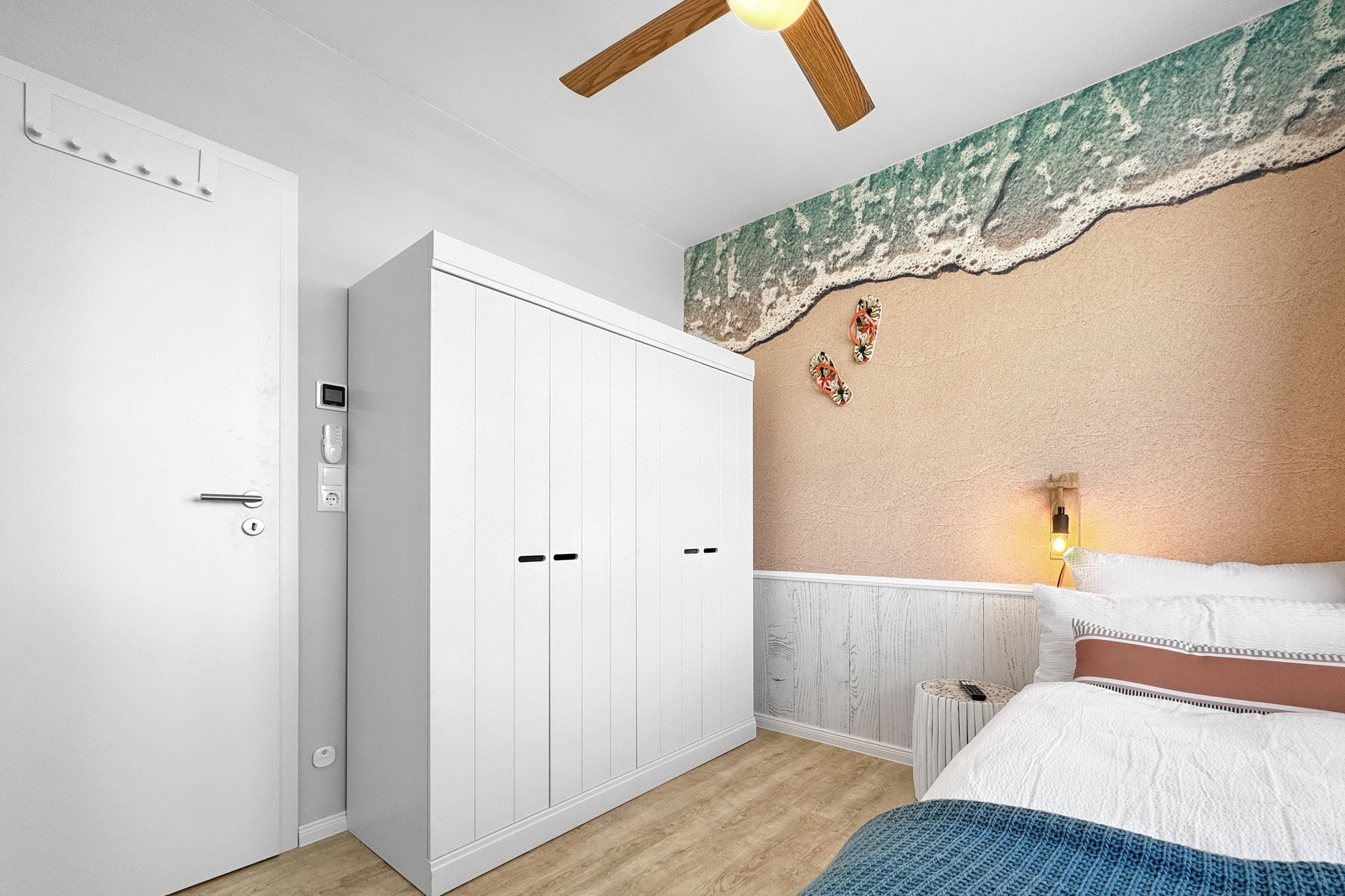 gemütliches Kinderzimmer mit großem Kleiderschrank und großformatiger Fototapete in der Ferienwohnung Meeresbrise in Heiligenhafen