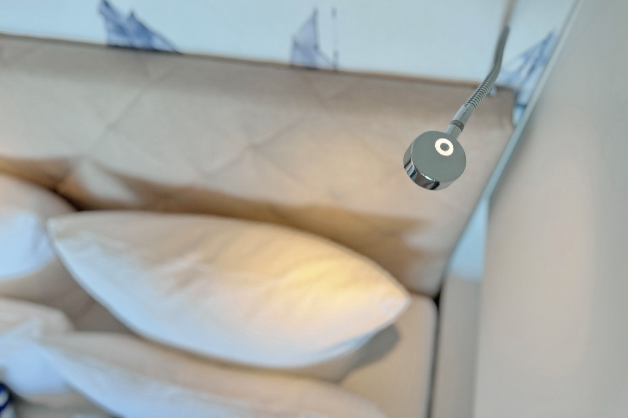 Detailansicht von oben auf das Boxspringbett und die Leselampe in der Ferienwohnung Meeresbrise in Heiligenhafen