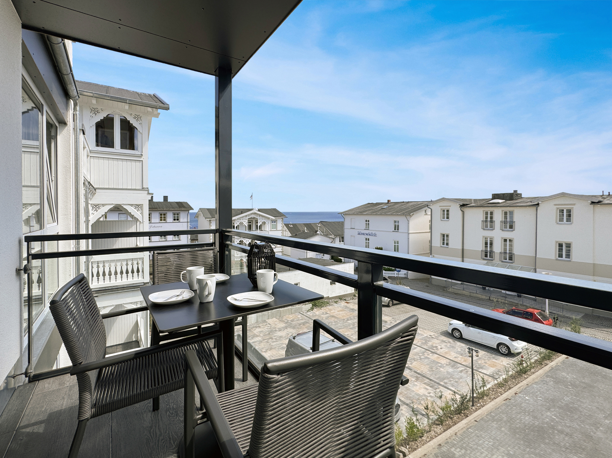 Balkon mit Bistrotisch und bequemen Stühlen