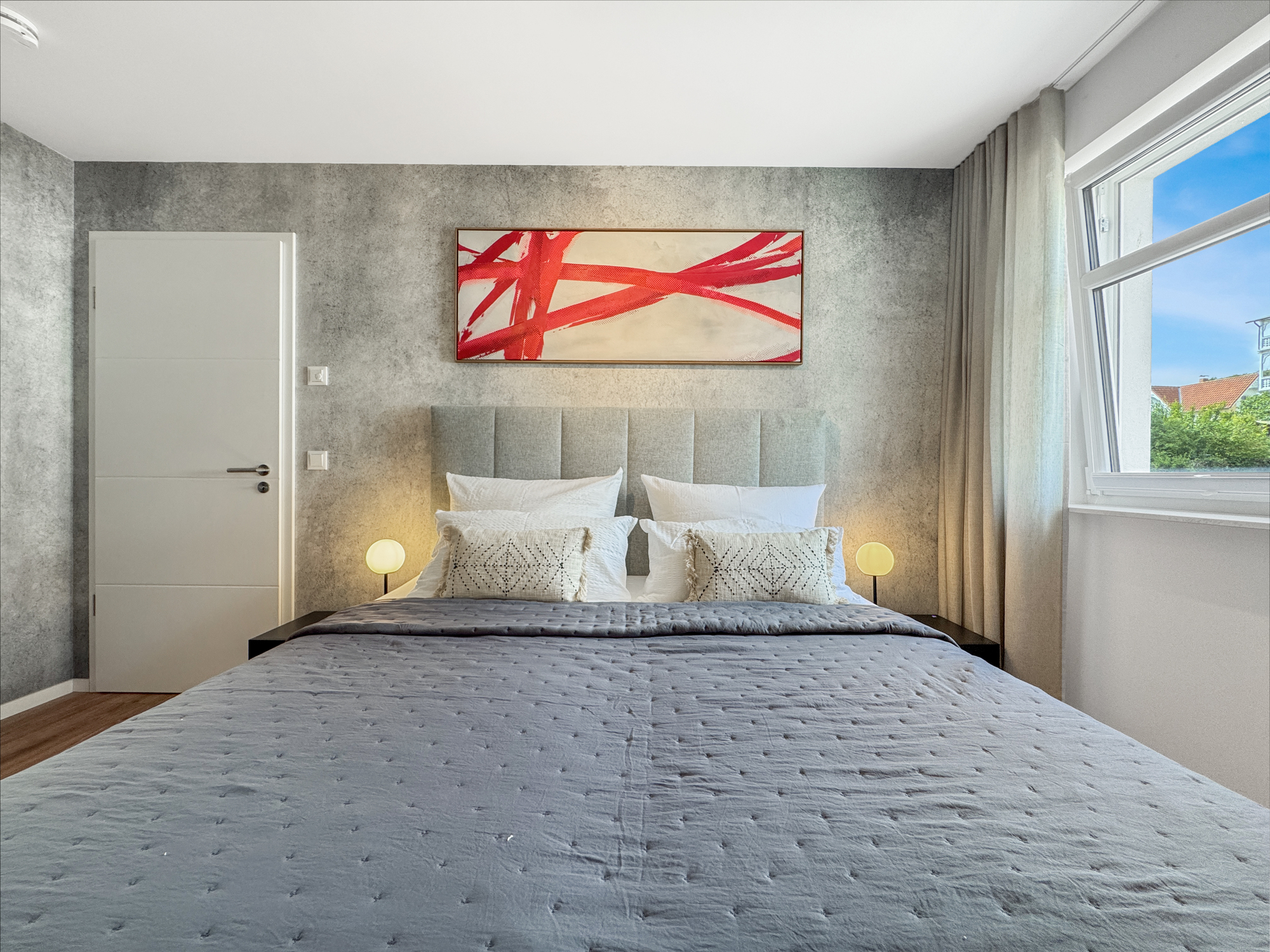 Hochwertig ausgestattetes Schlafzimmer mit Boxspringbett, Sichtbeton-Tapete und Wandkunst von Jürgen Katzenberger