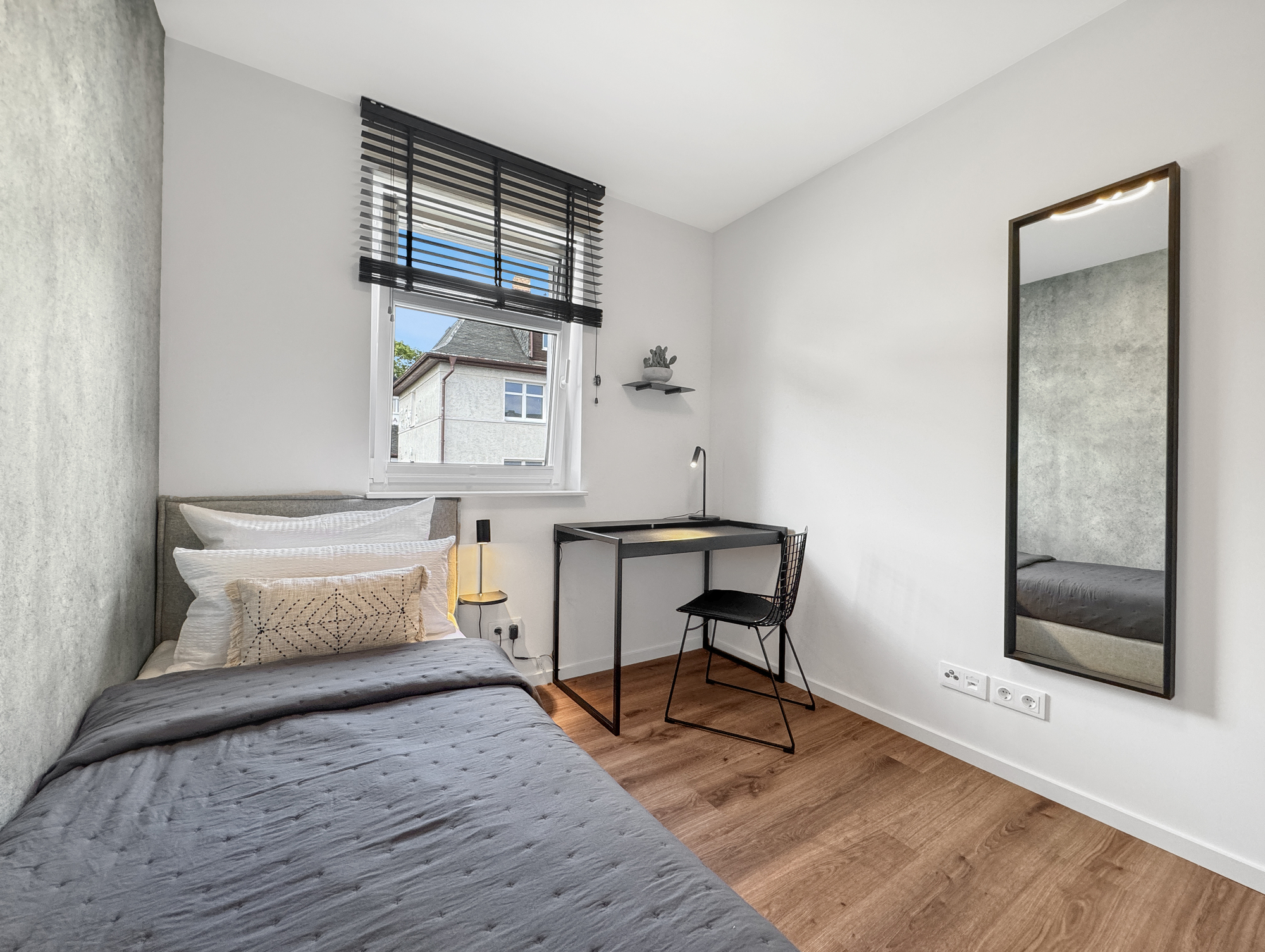 Zweit-Schlafzimmer mit Einzel-Boxspringbett und modernem Arbeitsplatz in der Fewo Freiraum Fünf in Sassnitz
